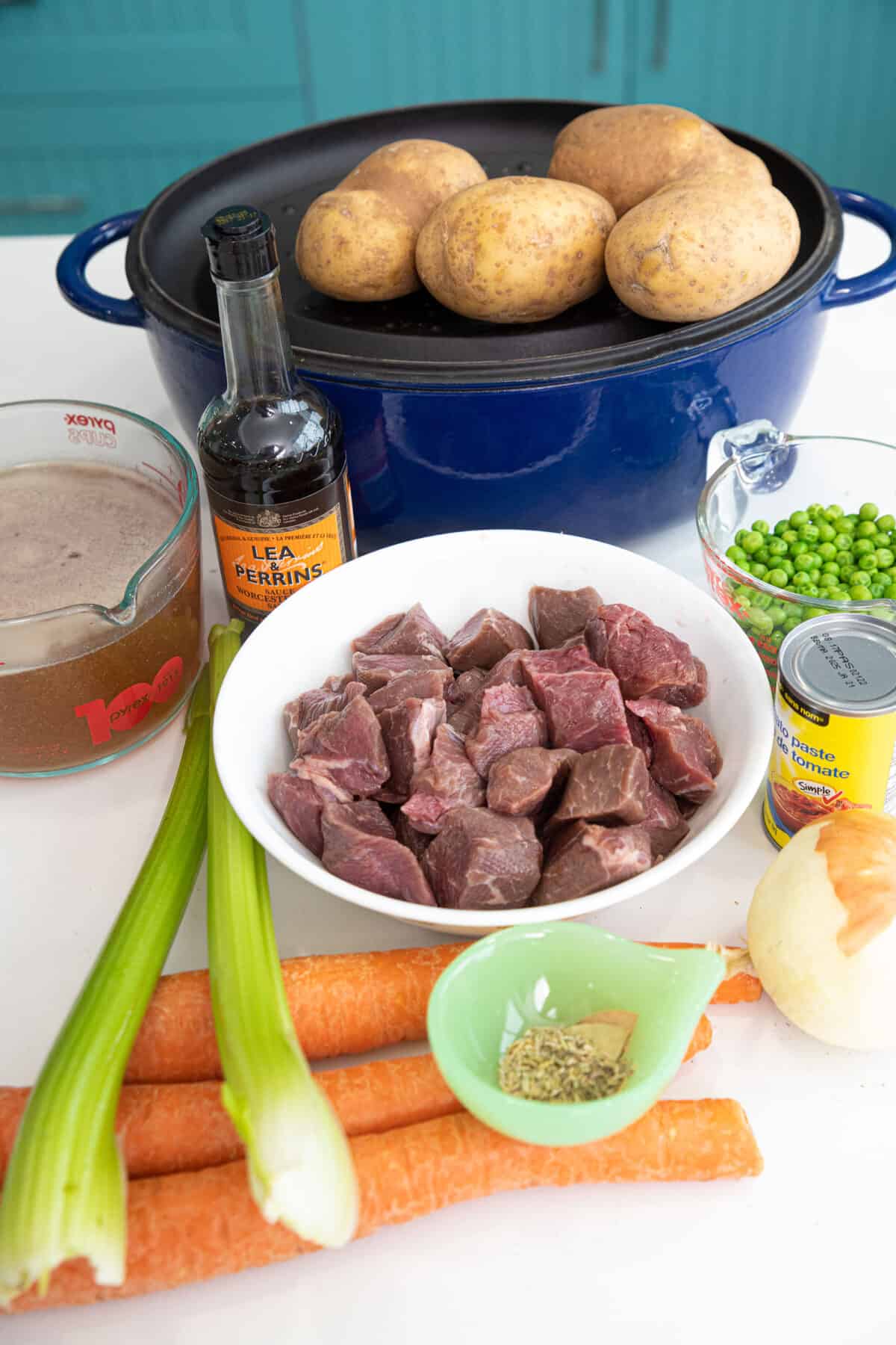 This hearty and delicious beef stew is made in a Dutch oven and is a delicious meal for the whole family. #thekitchenmagpie #beefstew #easyrecipe Dutch oven with ingredients around it.