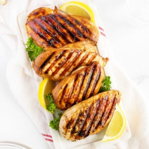 Grilled Chicken Breasts in a line on a cutting board